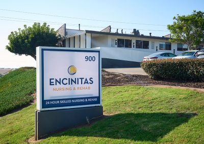 Front of the Encinitas Nursing and Rehab facility showing the building, the green grass, and sign