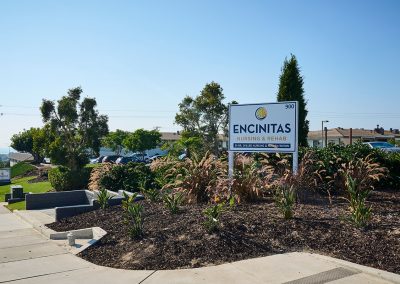 Front of the Encinitas Nursing and Rehab facility showing the building, the plants, and sign