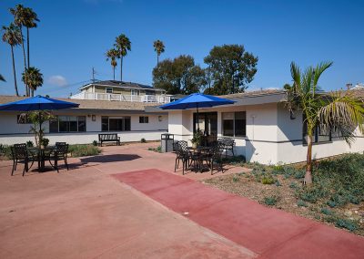 Back patio of the Encinitas Nursing and Rehab facility showing the building, and courtyard